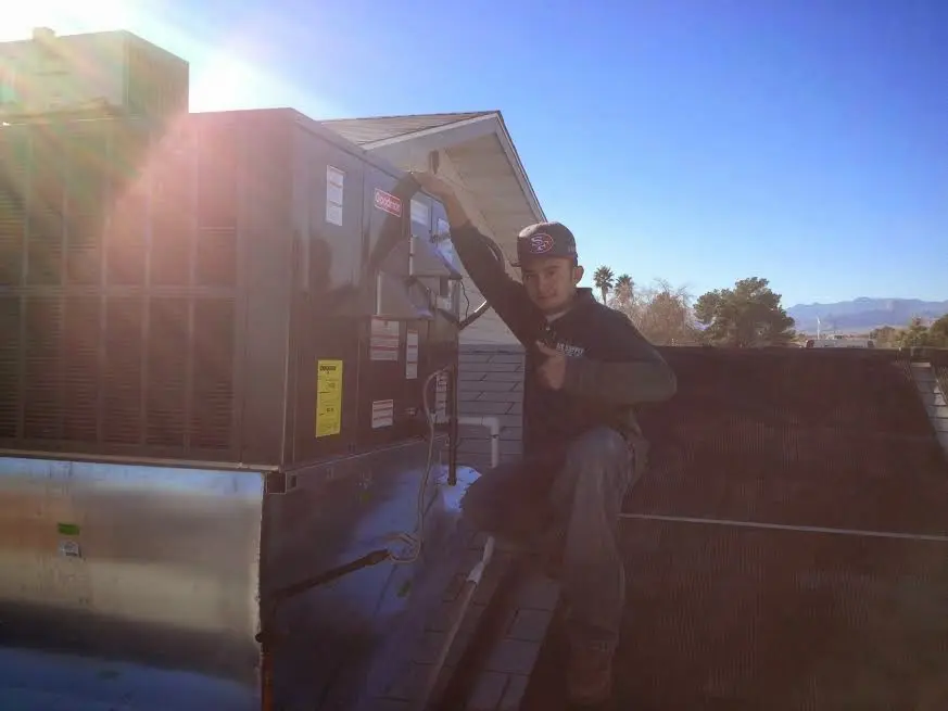 HVAC technician performing HVAC Inspection on a rooftop unit in Kings Park West